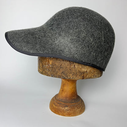Gray cap on a wooden mannequin head against a white background