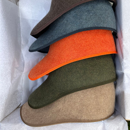 Stack of felted hats in various colors on a white background