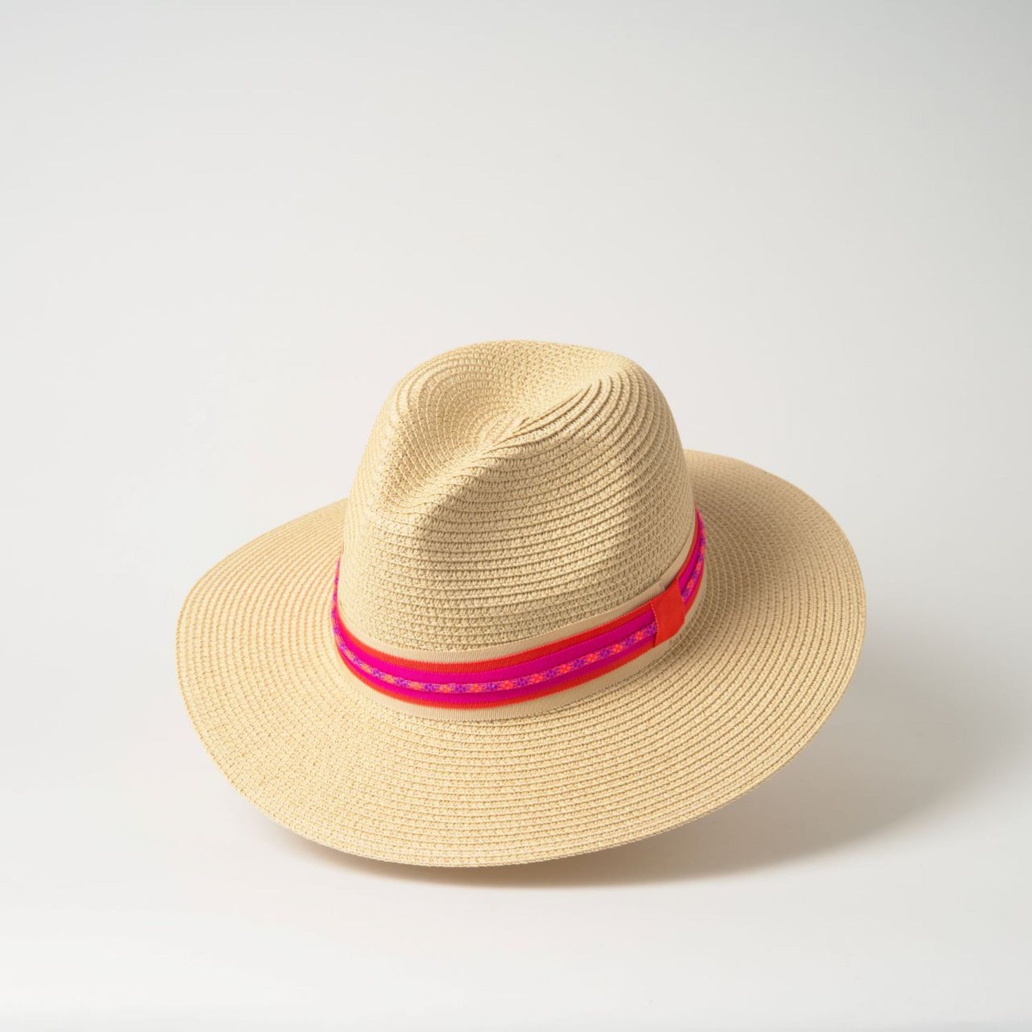 Beige straw hat with a pink band on a white background